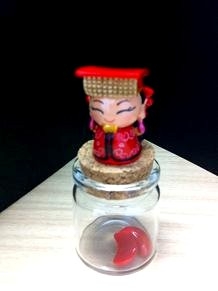 「瓶中筊」（Ｑ版媽祖の人形の下についた瓶の中に台湾ではおなじみの占いの道具ポエが入ったもの）