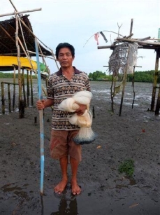 クドンガナン村の漁師（引き潮のマングローブ林を抜け漁船置き場に出るところ）